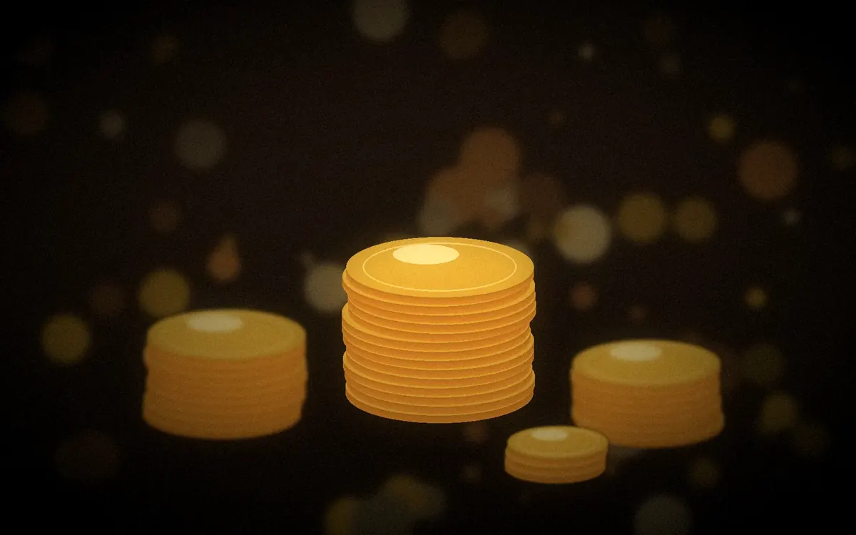 Stacks of gold-coloured coins on a dark brown background with soft bokeh